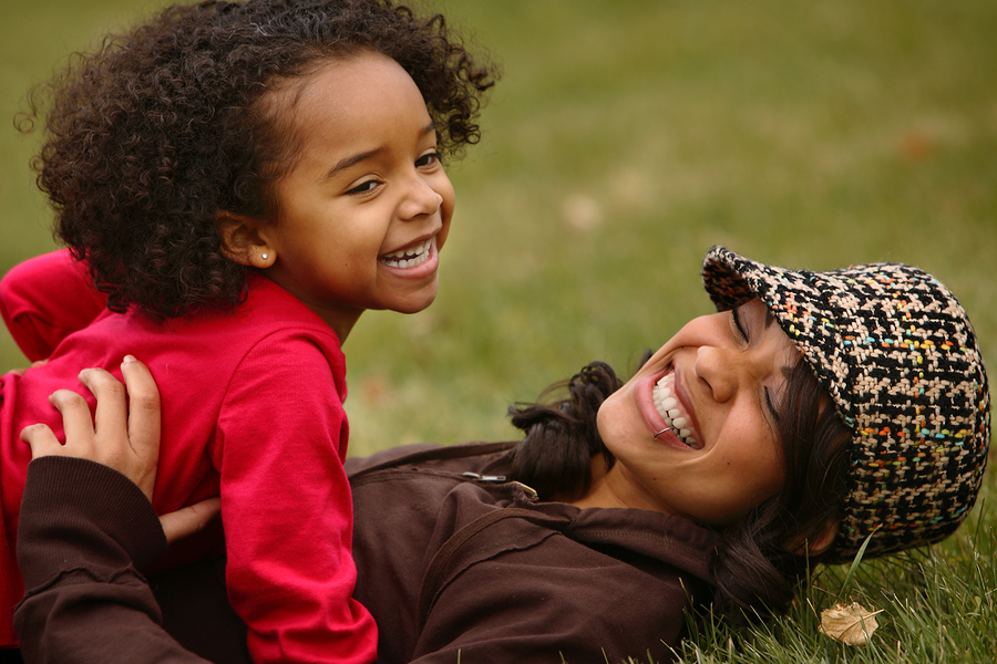 Single woman with child playing on grass