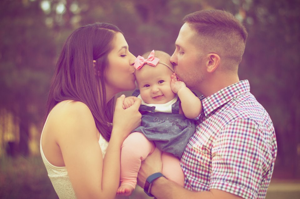 Co-parents kissing their baby