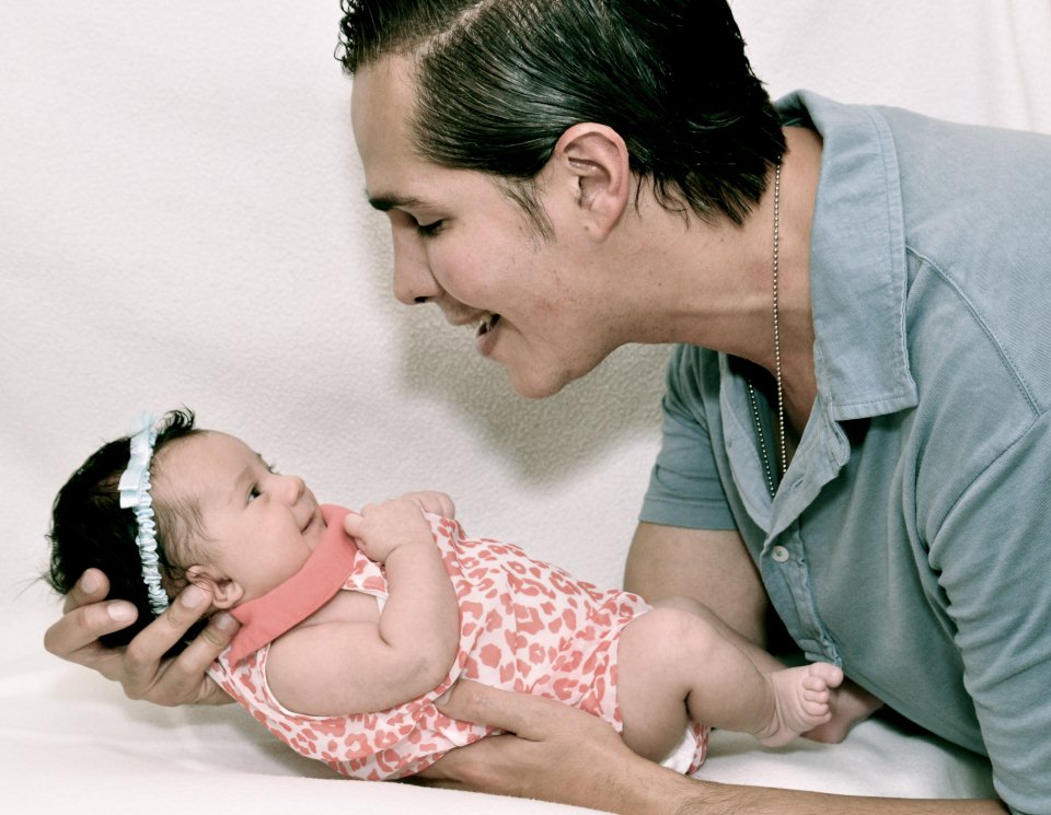 A co-parentmatch sperm donor member smiling at his newborn baby girl