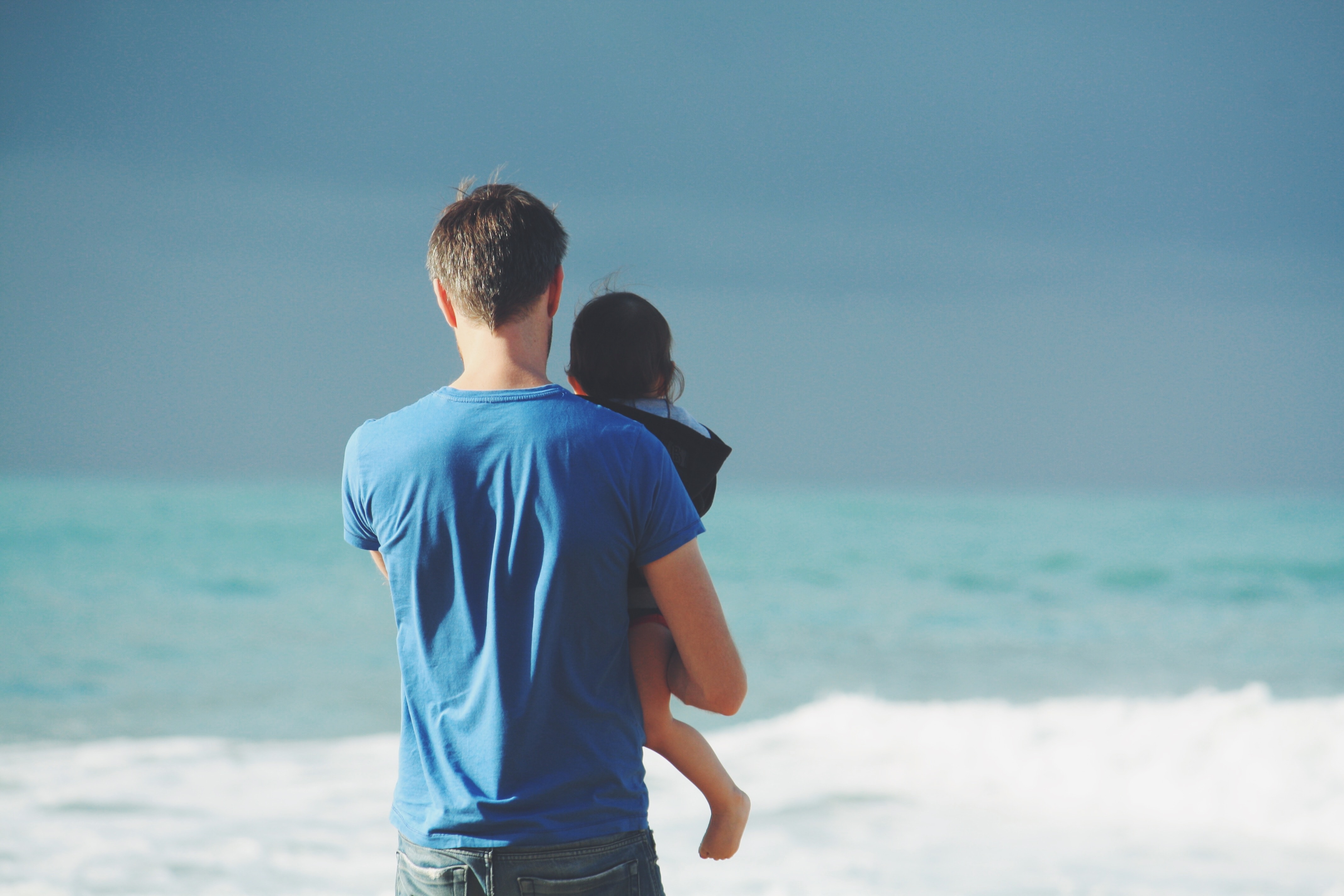 Man on beach holding child