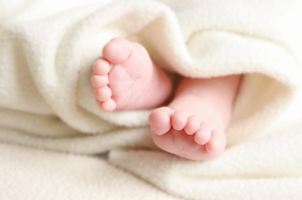 Baby feet wrapped in white blanket