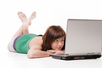 Lady lying down looking for sperm donor on a laptop