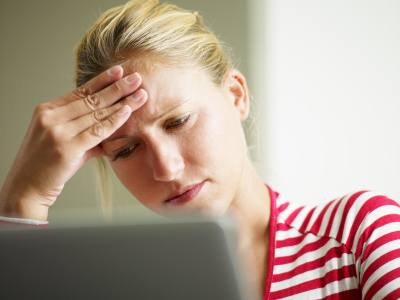 Caucasian blonde woman looking at sperm donor legal facts on laptop