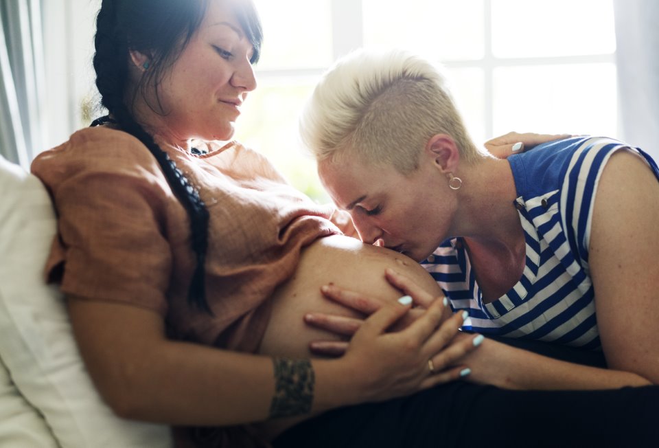 lesbian parents kissing pregnant belly