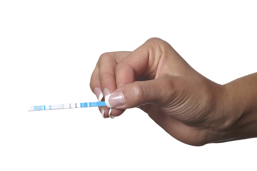 A woman's hand holding an ovulation test resut
