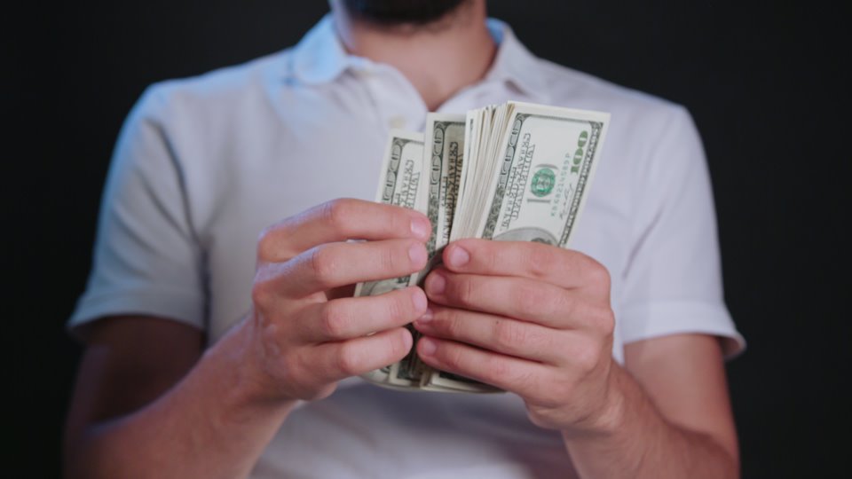 Man holding his sperm donor pay in cash